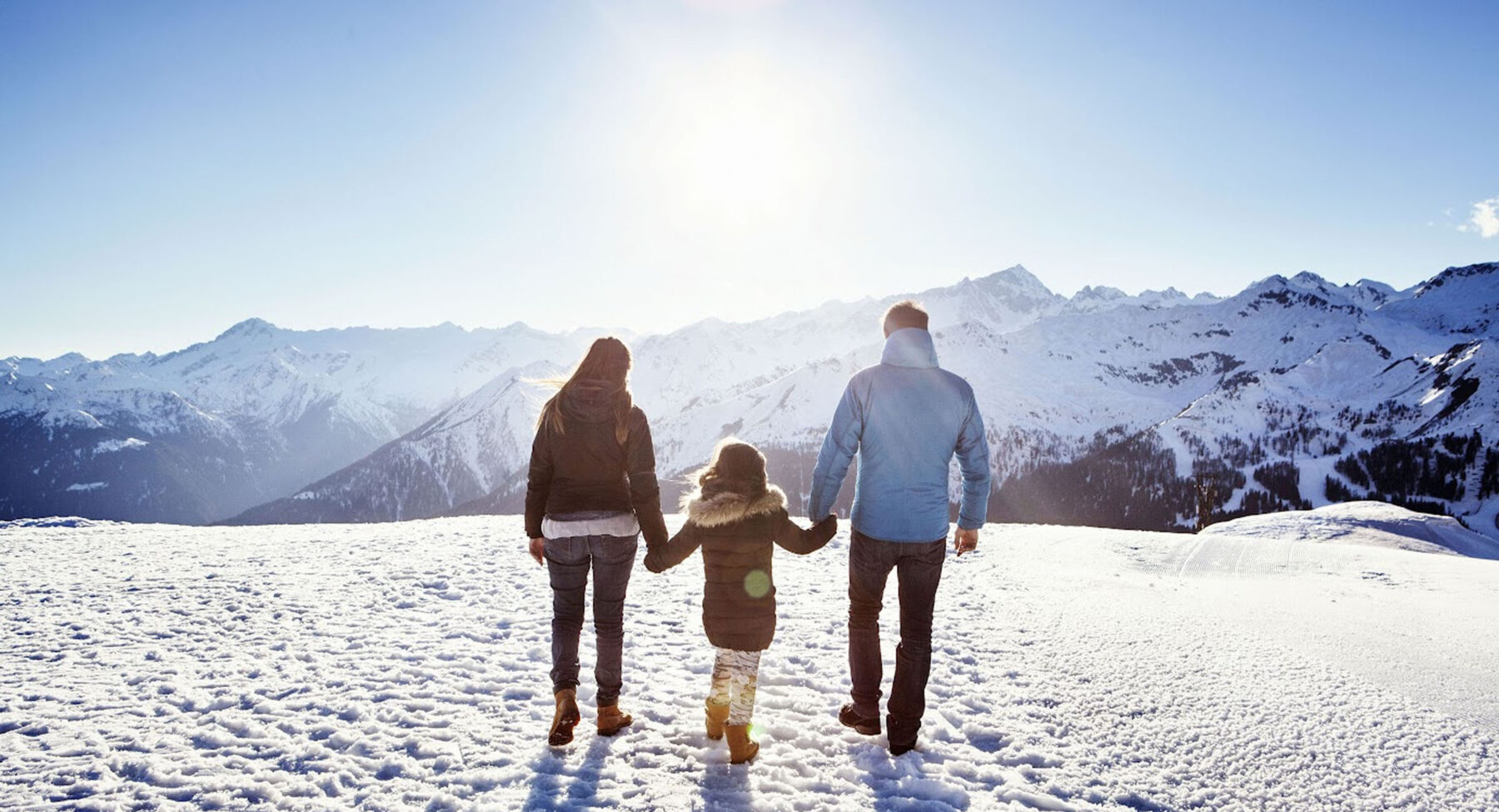 A family holding hands on a snowy mountain